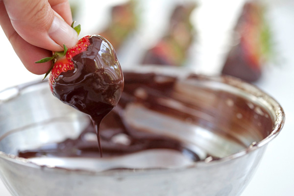 Dipping the strawberries into the melted chocolate